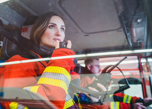 female firefighter using a radio inside an emergency vehicle