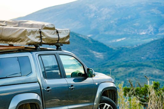 a car with luggage on the rooftop nearby hillside