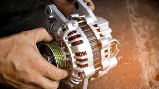 person holding a car alternator with visible copper windings
